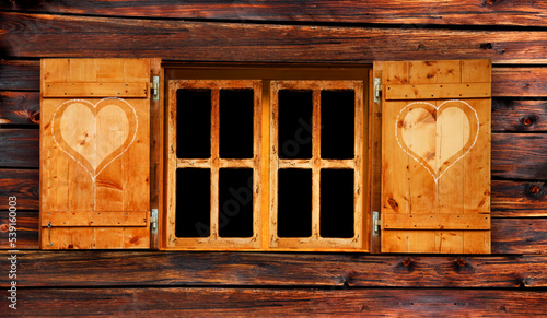 Holzfenster mit Fensterladen und Herzchendekor