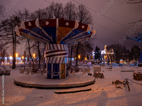 Old carousel in an abandoned park in winter at night. Abandoned Moscow amusement park.