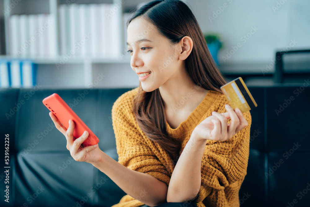 happy asian business woman Pay online using your mobile phone at home happy asian business woman Pay online using your mobile phone at home