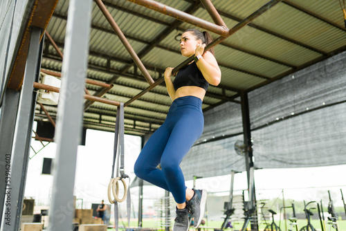 Athletic young woman exercising doing chin ups