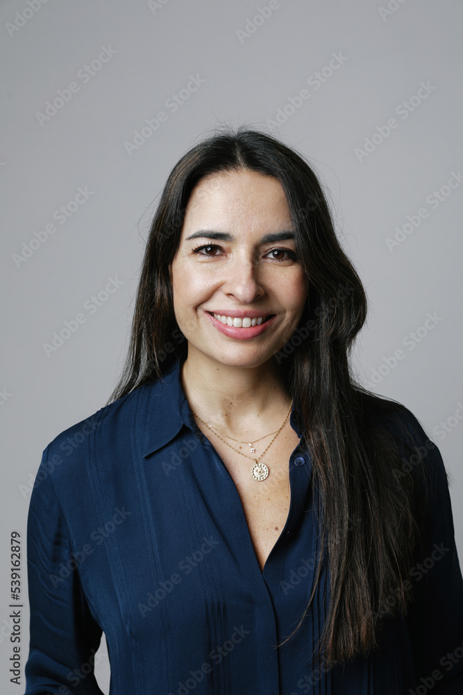 Happy and optimistic beautiful middle-aged woman posing on white wall. Vertical. Happy and optimistic beautiful middle-aged woman posing on white wall. Vertical.