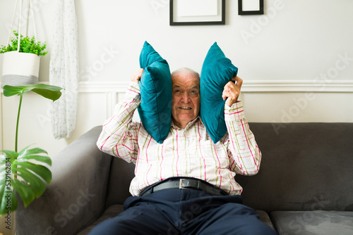 Stressed old man suffering because of the loud music of his neighbors