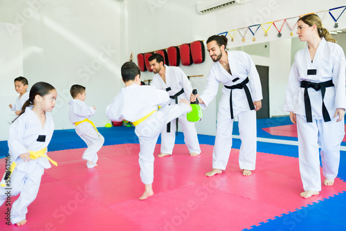 Karate trainers practicing taekwondo with children