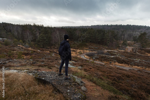 A man with a backpack standing on top of a hill on a mountain.