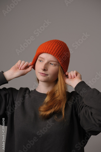 young girl model in orange cap isolated on gray background. Product photo mockup for fashion brands and marketplaces.