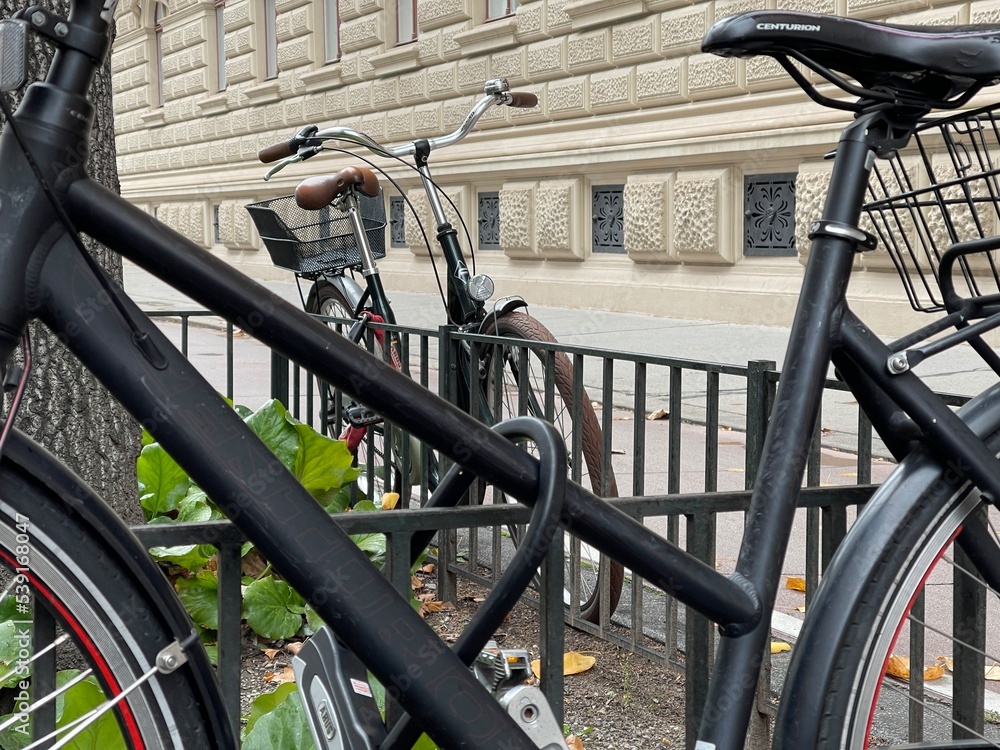 Cropped shot of bicycles parked near the fence in the city Cropped shot of bicycles parked near the fence in the city