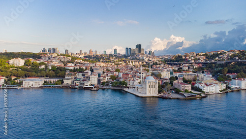 Skyscrapers of istanbul behind Ortaköy Camii mosque and city behind, aerial view of the Bosporous in Istanbul
