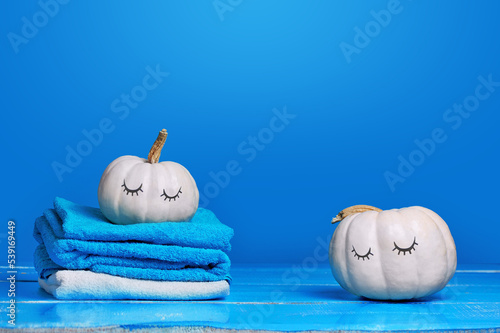 Stil llife with white pumpkins and towels against blue background photo