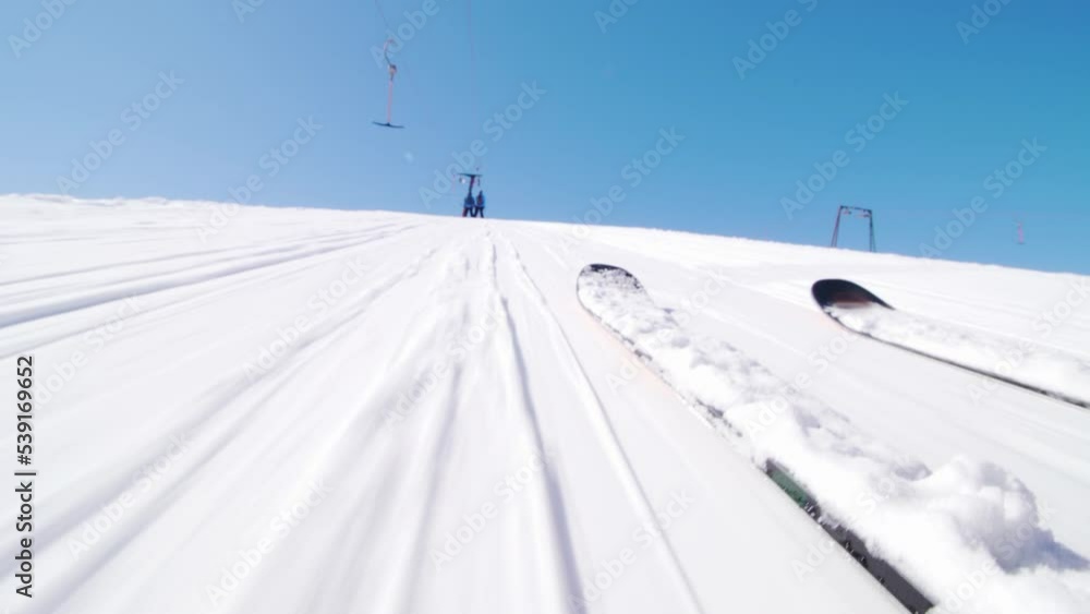 Skiers on a ski lift. Low angle view focus on skis. Skiers on a ski lift. Low angle view focus on skis.