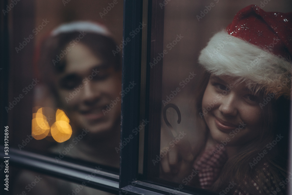 Romantic couple in love feel happiness from their romance while spending Christmas together, woman and man enjoying perfect relationship in cozy home interior. High quality photo