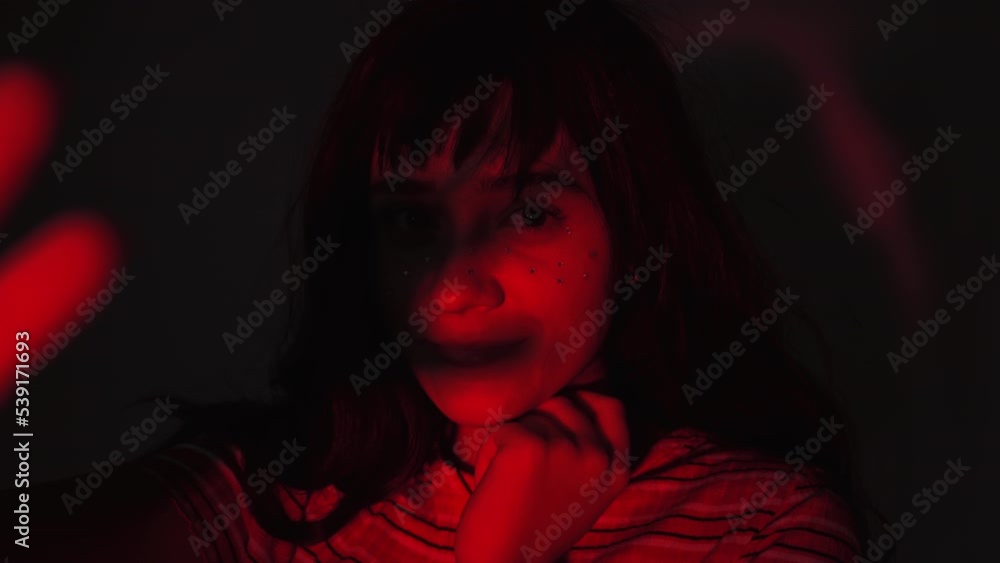 Artistic Portrait Of A Pretty Woman With Face Gems, Hand Shadow On Her Face In Warm Red Light. close up Artistic Portrait Of A Pretty Woman With Face Gems, Hand Shadow On Her Face In Warm Red Light. close up