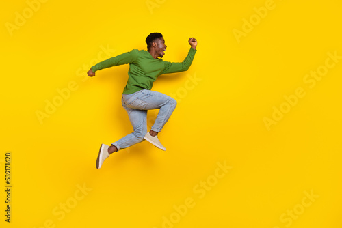Full length body size view of attractive cheerful crazy guy jumping running isolated over bright yellow color background