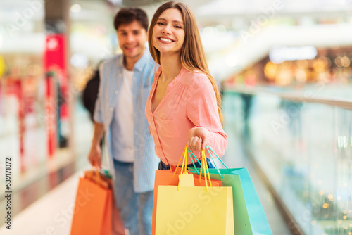 Cheerful Wife And Husband Shopping Walking, Holding Hands In Mall