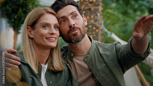 Loving married couple husband and wife Caucasian bearded man and blonde woman 40s spouses sit outdoors looking into distance dreaming contemplating thinking about future talking conversation cuddling