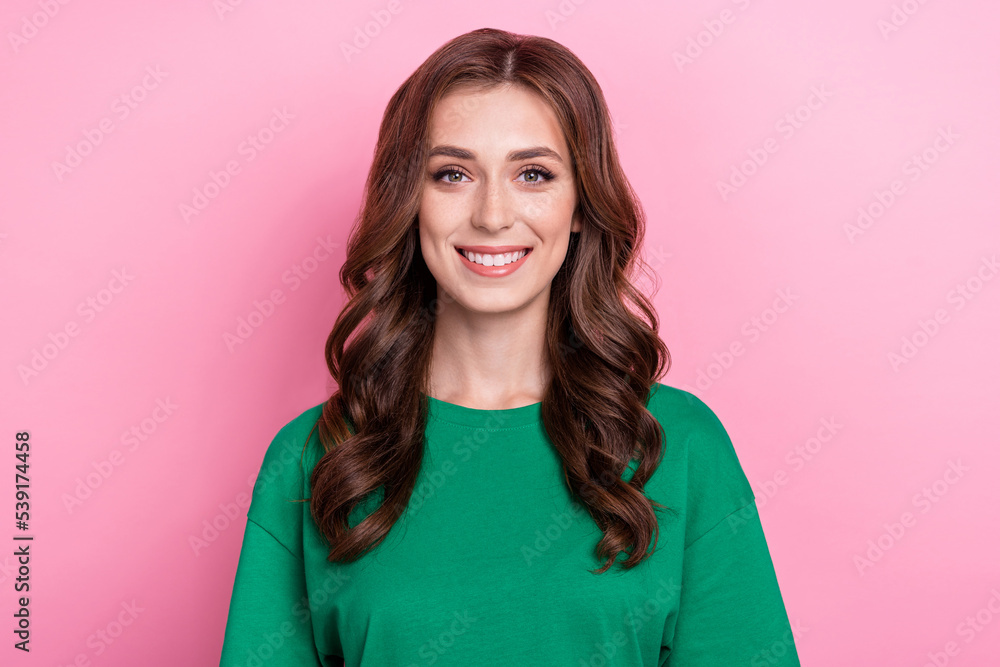 Photo of good mood optimistic woman with curly hairstyle dressed green t-shirt smiling at camera isolated on pink color background Photo of good mood optimistic woman with curly hairstyle dressed green t-shirt smiling at camera isolated on pink color background