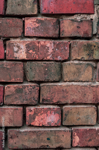 Faded old red brick wall, wide rough vintage texture. Dirty wall with grunge rectangular blocks, close-up, grungy texture of blackened bricks.