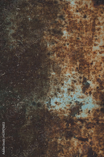 Rusty sheet of metal with peeling faded paint, covered with dust and dirt, grungy texture surface, close-up vintage background.