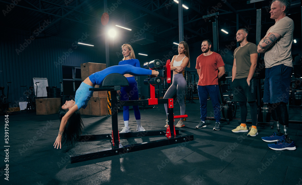 Young men and women in sports uniform workout at sport gym, indoors. Sport, active lifestyle, health, youth concept Young men and women in sports uniform workout at sport gym, indoors. Sport, active lifestyle, health, youth concept