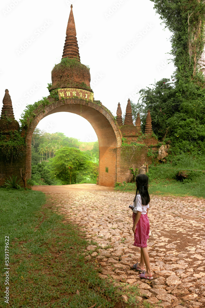 little girl standing at Temple gate at Khao Na Nai Luang Dharma Park in Surat Thani