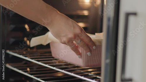 Close up, girl placing fall baking recipe in oven