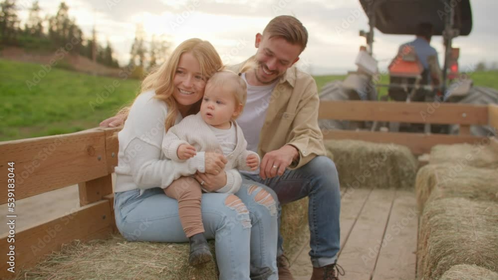 Young family on tractor ride, sunset Young family on tractor ride, sunset