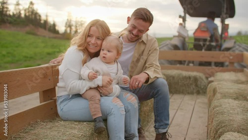 Young family on tractor ride, sunset