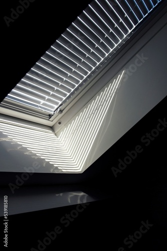 A side portrait of a velux roof window with a closed jalousie in it to keep the sun and warmth out or to keep the light from entering the room in the morning when people are still trying to sleep. photo