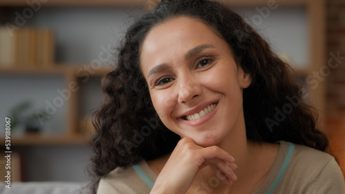 Indoors portrait extreme close up female face with perfect skin make-up pensive dreaming thoughtful Hispanic 30s woman adult girl at home looks to side turn head looking at camera smiling toothy smile