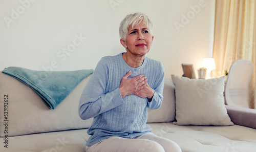 Female with chest pain. Senior woman suffering from heartburn or chest discomfort symptoms. Acid reflux or Gastroesophageal reflux disease (GERD) concept photo