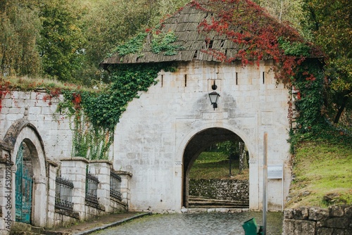 Entrance of the Gradacac Castle covered by green and red leaves in Bosnia and Herzegovina photo