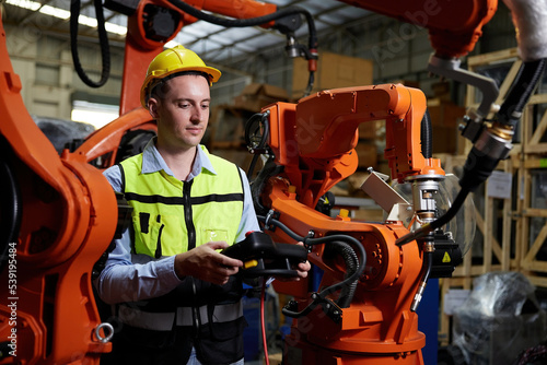 factory worker or engineer operating remote switch controller to control robot machine in the factory © offsuperphoto