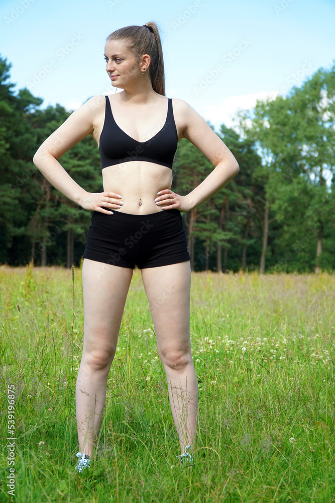 Sporty slim young woman in nature preparing for sport exercise Sporty slim young woman in nature preparing for sport exercise