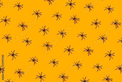 Repeated spiders on orange background. Halloween party