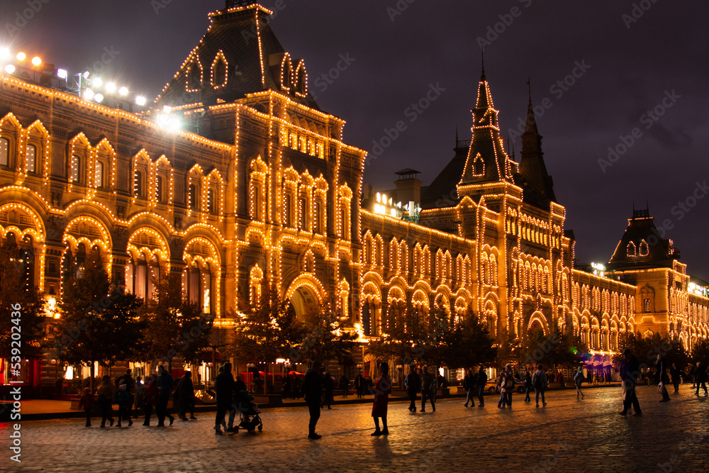 Fototapeta premium MOSCOW, RUSSIA - October 6, 2022: Golden building GUM burning with evening magic illumination. New Year and Christmas atmosphere in the center of Moscow