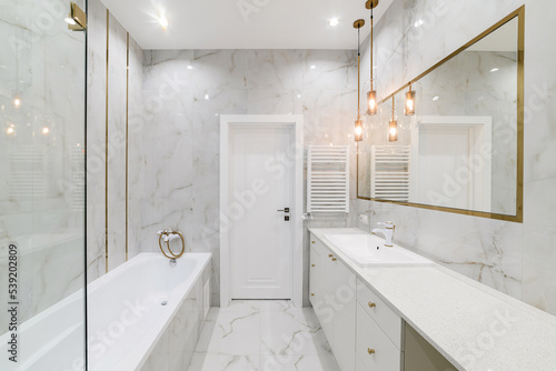 bathroom interior design with light tiles and a mirror