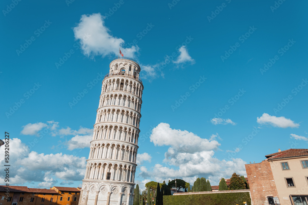 Amazingly beautiful historical building tower with Romanesque architecture and columns on blue sky in Pisa, Italy