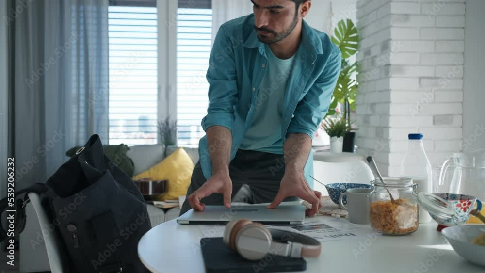 Young man hurrying up to work, taking stuff Young man hurrying up to work, taking stuff