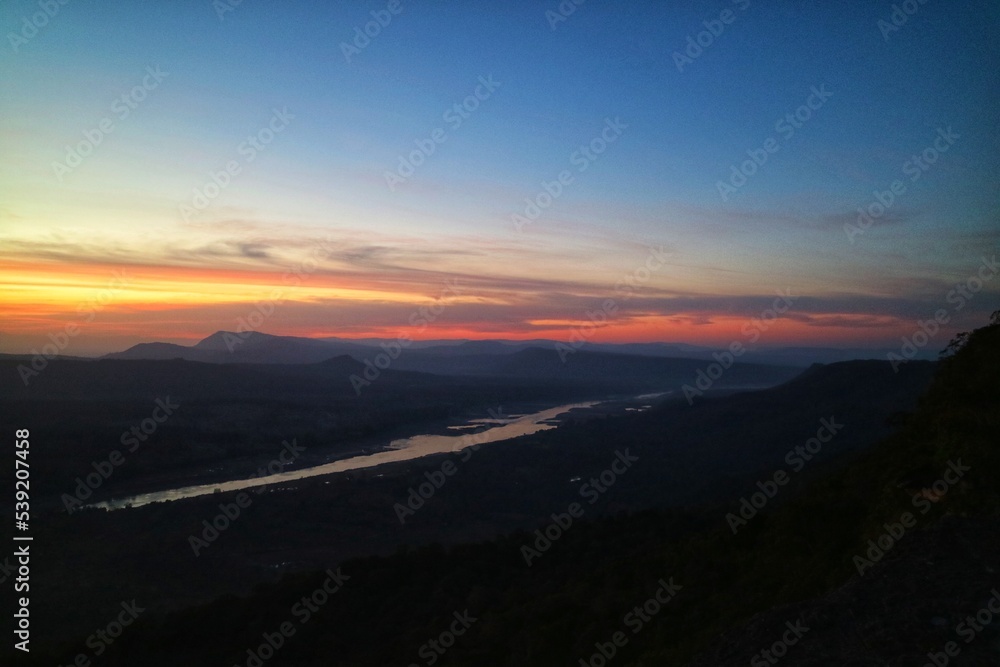 Obraz premium sunrise in the mountains, nature background the first sunrise at Pha Chana Dai near Mae Khong River in Ubon Ratchathani, Thailand. 