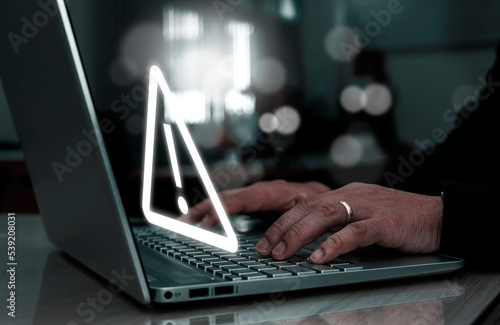 Businessman using computer laptop with triangle caution warning sing for notification error and maintenance concept