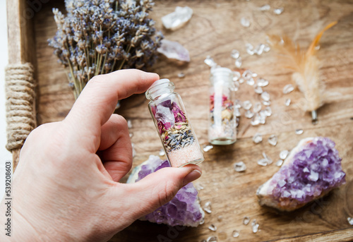 Foto Woman hand holding homemade spell jar bottle with good intentions for home protection and inner balance