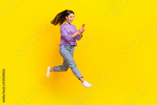 Full length photo of positive blogger runner user fly air hurry shopping sale discount go empty space isolated on yellow color background