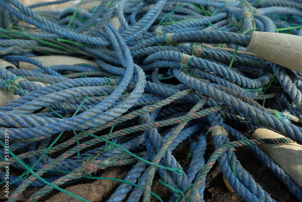 Detail view and background of used fishing net ropes and buoys