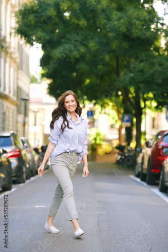 Fashion portrait of beautiful young woman, wearing blue shirt, posing outdoors