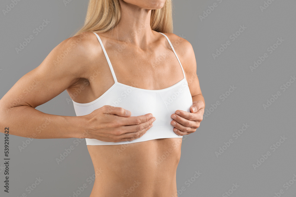 Breast Augmentation Concept. Unrecognizable Female In White Top Touching Chest Area