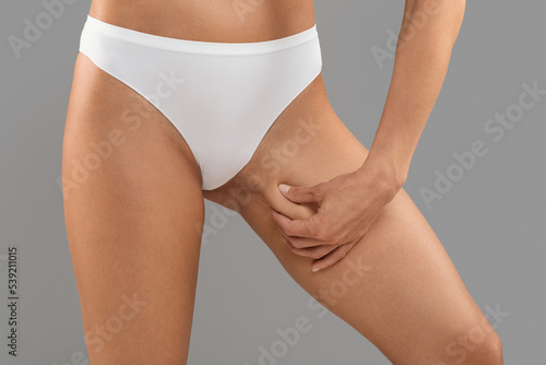 Liposuction Concept. Slim Woman In White Panties Touching Inner Thigh Skin