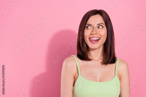 Photo of shiny cunning young girl dressed green outfit licking lips looking empty space isolated pink color background © deagreez