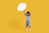Great news. Happy little boy holding blank speech bubble and showing thumb up, smiling widely, empty space