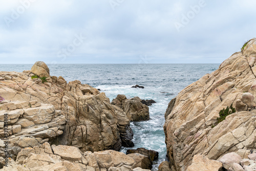 California, USA - May 18, 2018: gap between two giant rocks against blue sky on the ocean. coastal scenery along Pacific coast highway in united states