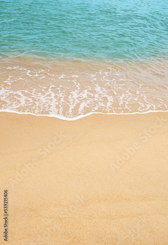 Sand beach and Blue ocean with soft wave form on Sand Texture, Brown Beach sand dune in sunny day Spring, Vertical top view for Summer banner background.