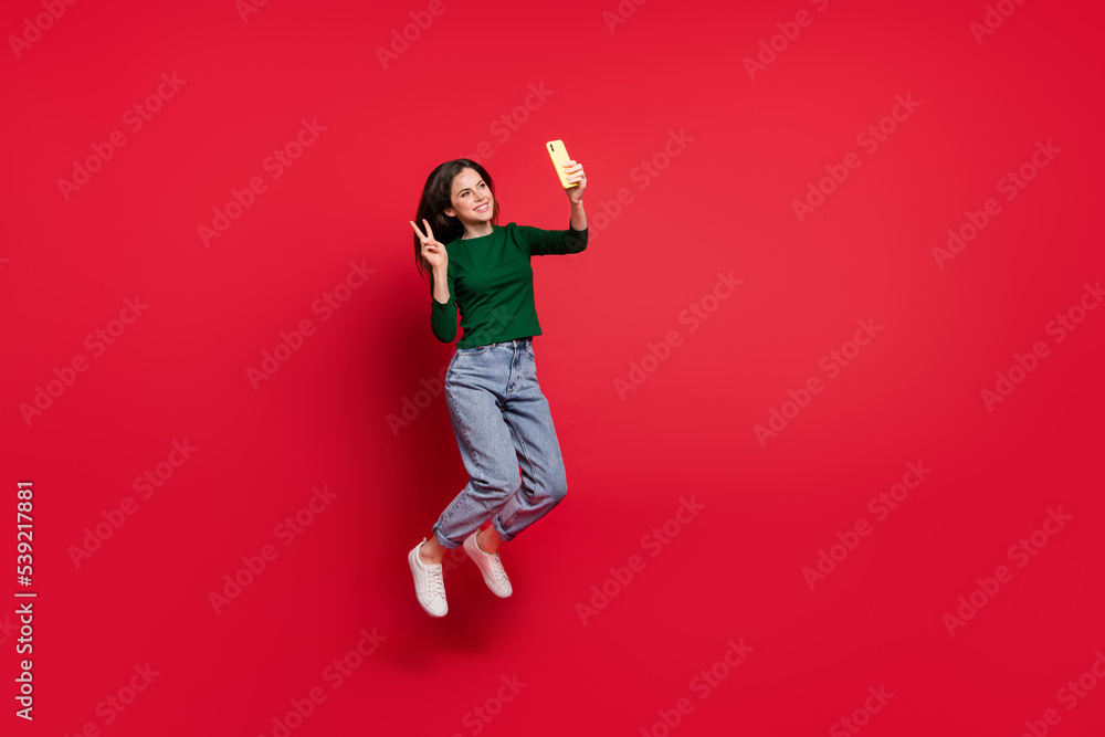 Full body photo of attractive carefree girl blogger recording video network wear trendy green garment isolated on shine red color background Full body photo of attractive carefree girl blogger recording video network wear trendy green garment isolated on shine red color background
